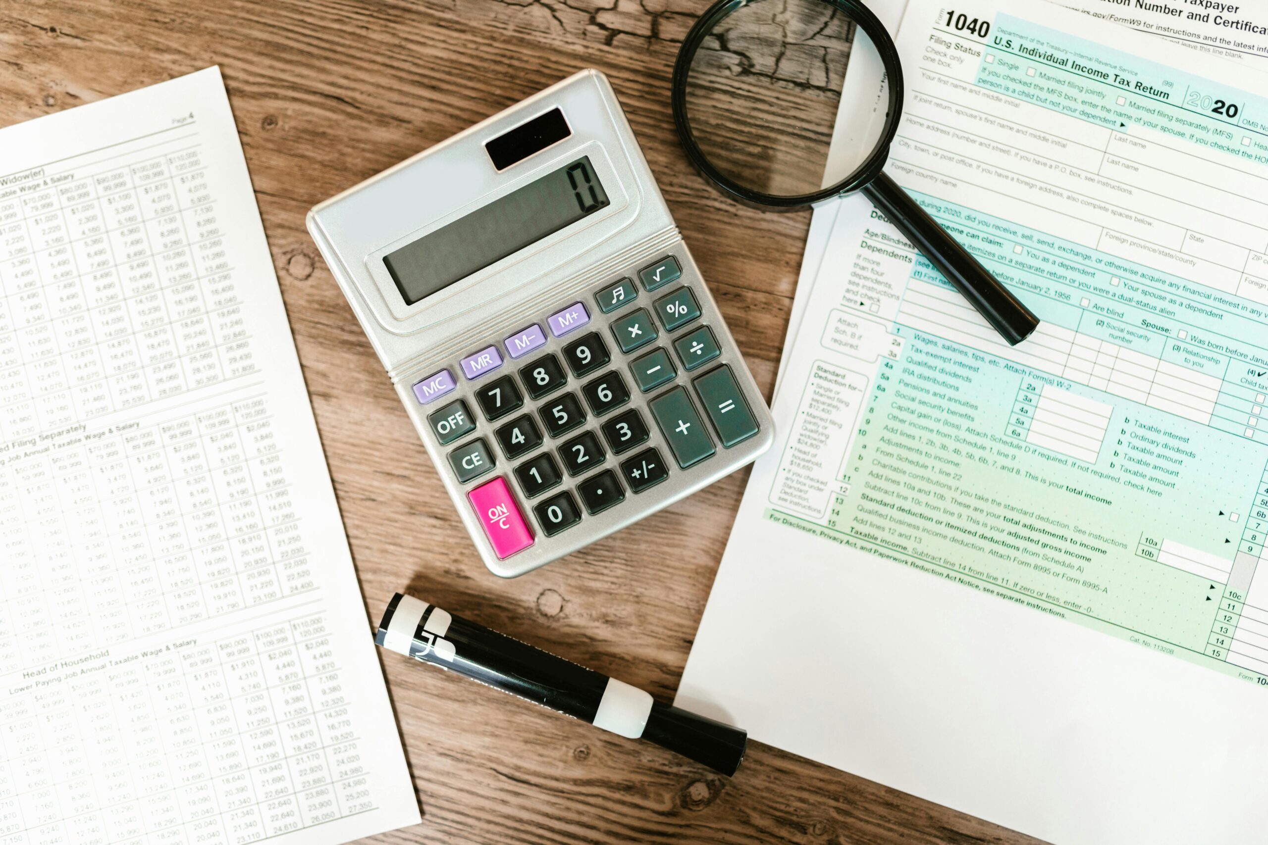 Calculator and financial documents on a wooden desk, highlighting salary for accountants.