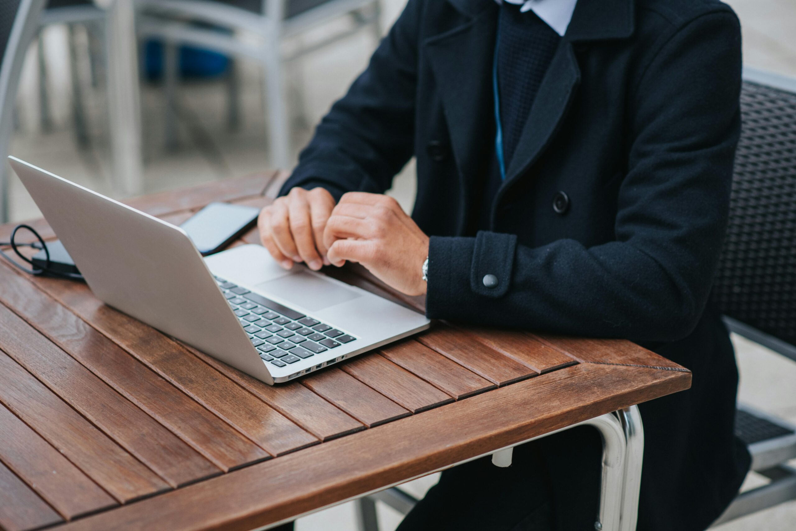 Person working on a laptop outdoors, highlighting the flexibility of a project management assistant.