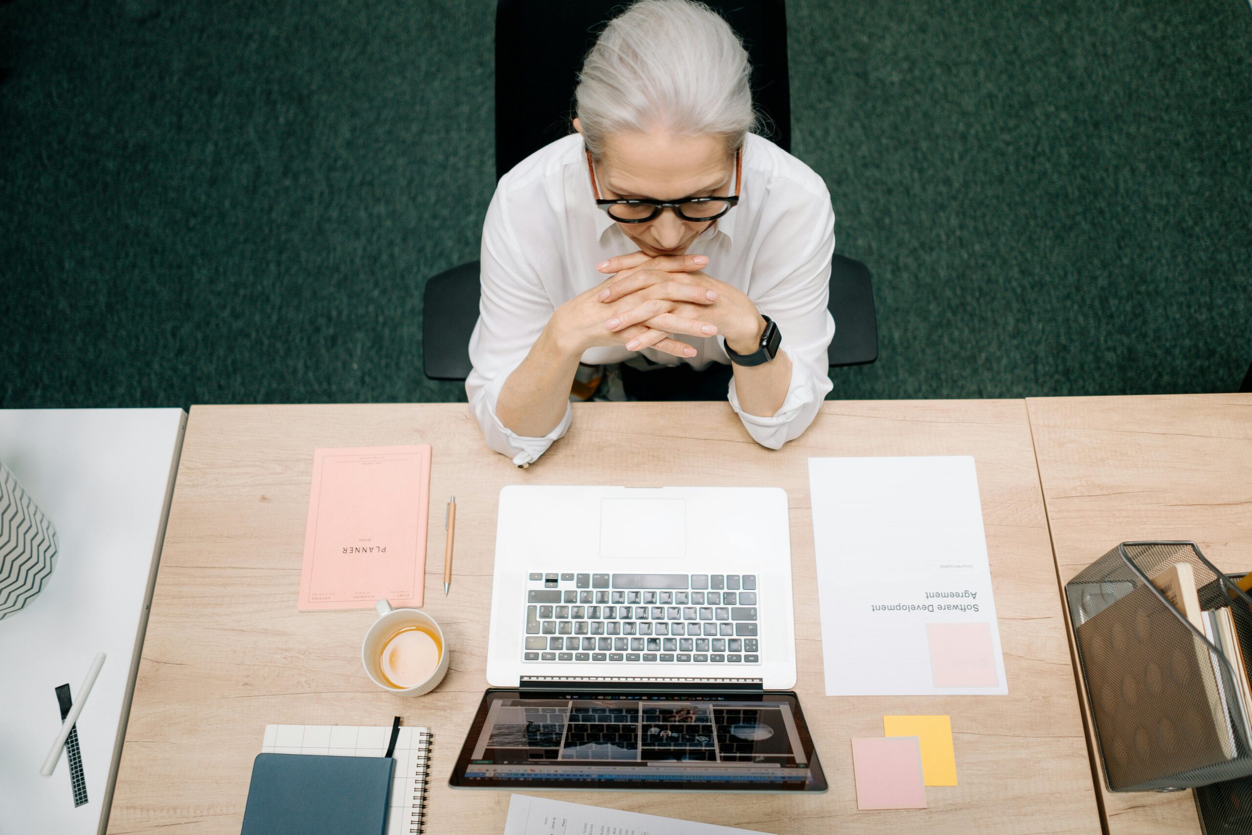 A professional contemplating a decision at a desk, reflecting on the insourcing vs outsourcing debate for business operations.