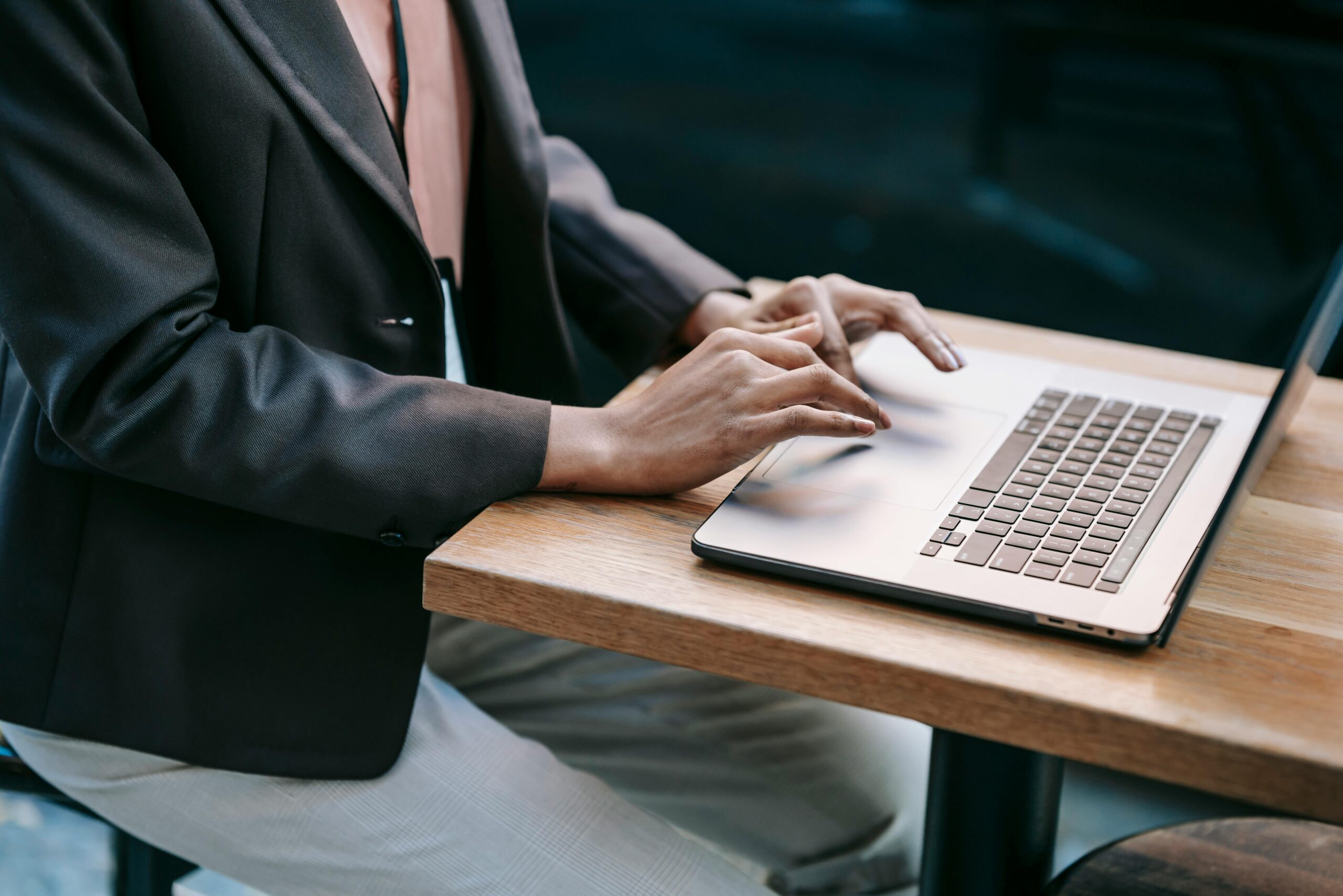 An executive assistant working on a laptop, fulfilling tasks outlined in the executive assistant job description.