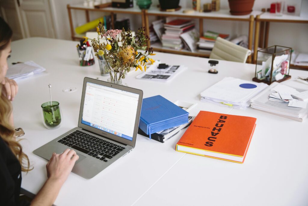 A recruiter working at a cluttered desk filled with office supplies and documents, highlighting their dynamic workspace.