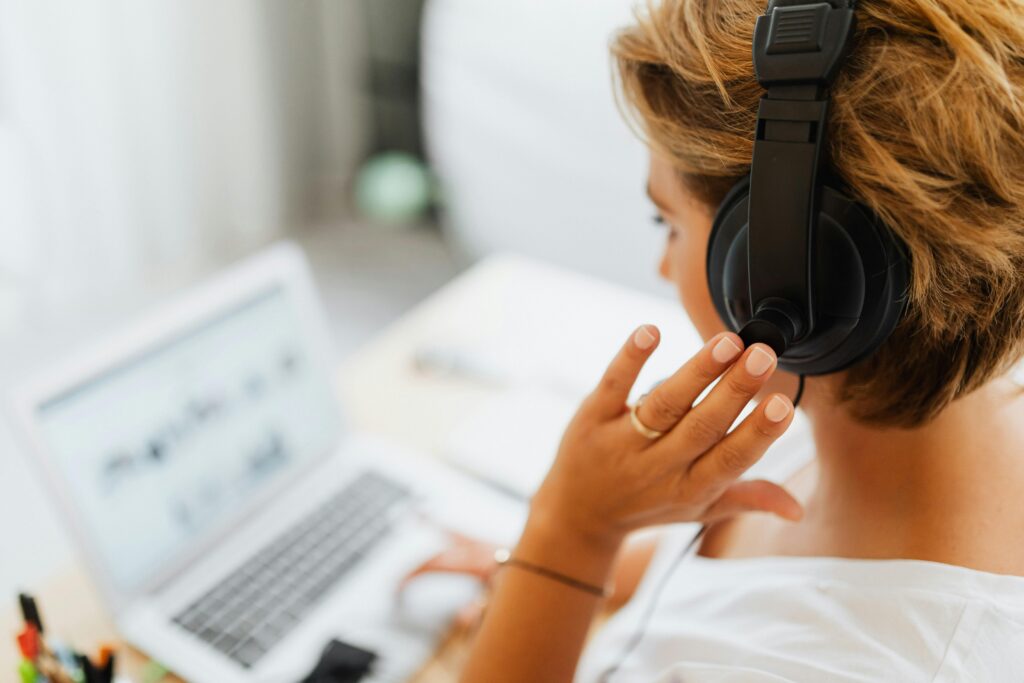 Inside sales outsourcing specialist working remotely with headphones and a laptop.