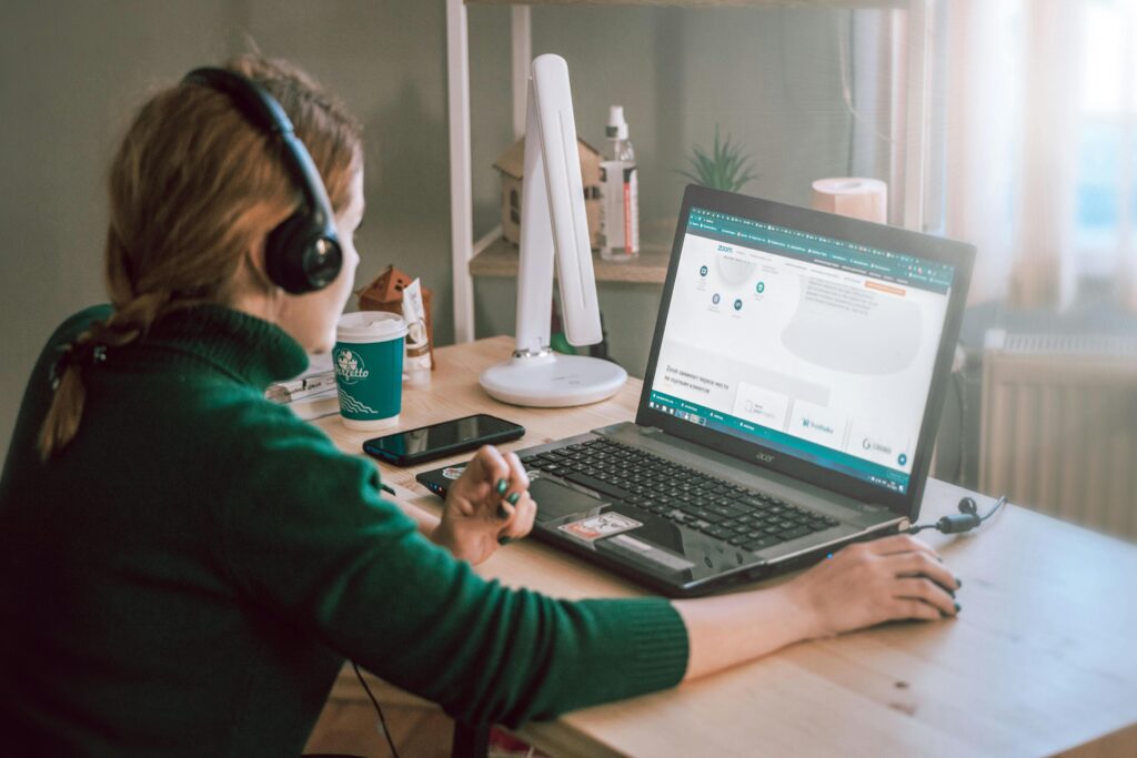 Remote worker managing sales development outsourcing using a laptop and headphones.
