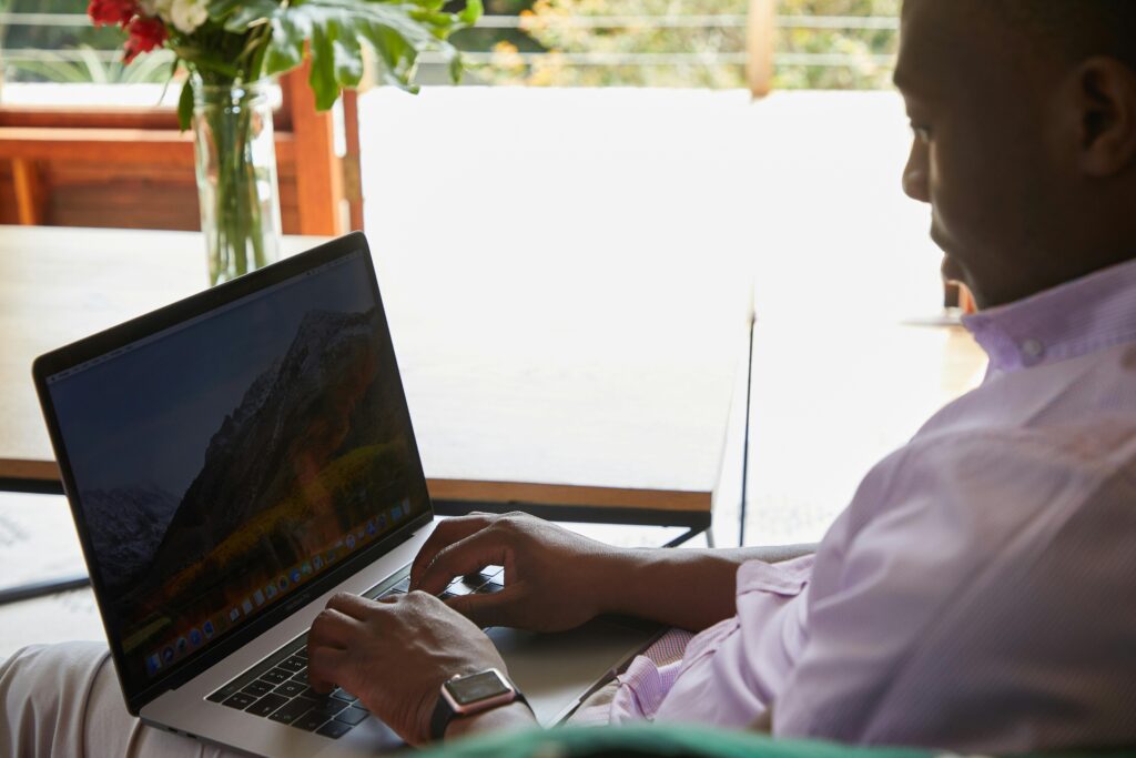 A man working on his laptop in a serene environment, representing the remote flexibility of real estate virtual assistance.