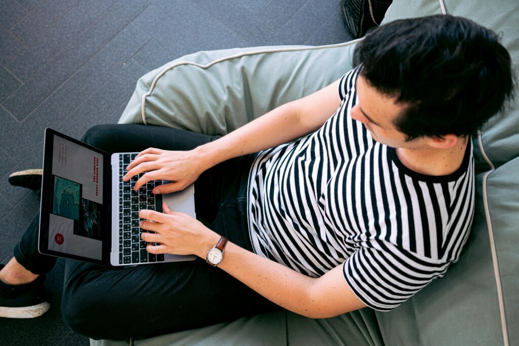 A marketing automation specialist key skills summary being reviewed on a laptop by a person sitting on a bean bag.
