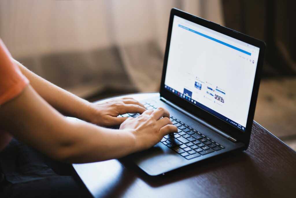 A paid media buyer working on a laptop, managing digital advertising cam-velascopaigns and analyzing performance metrics.