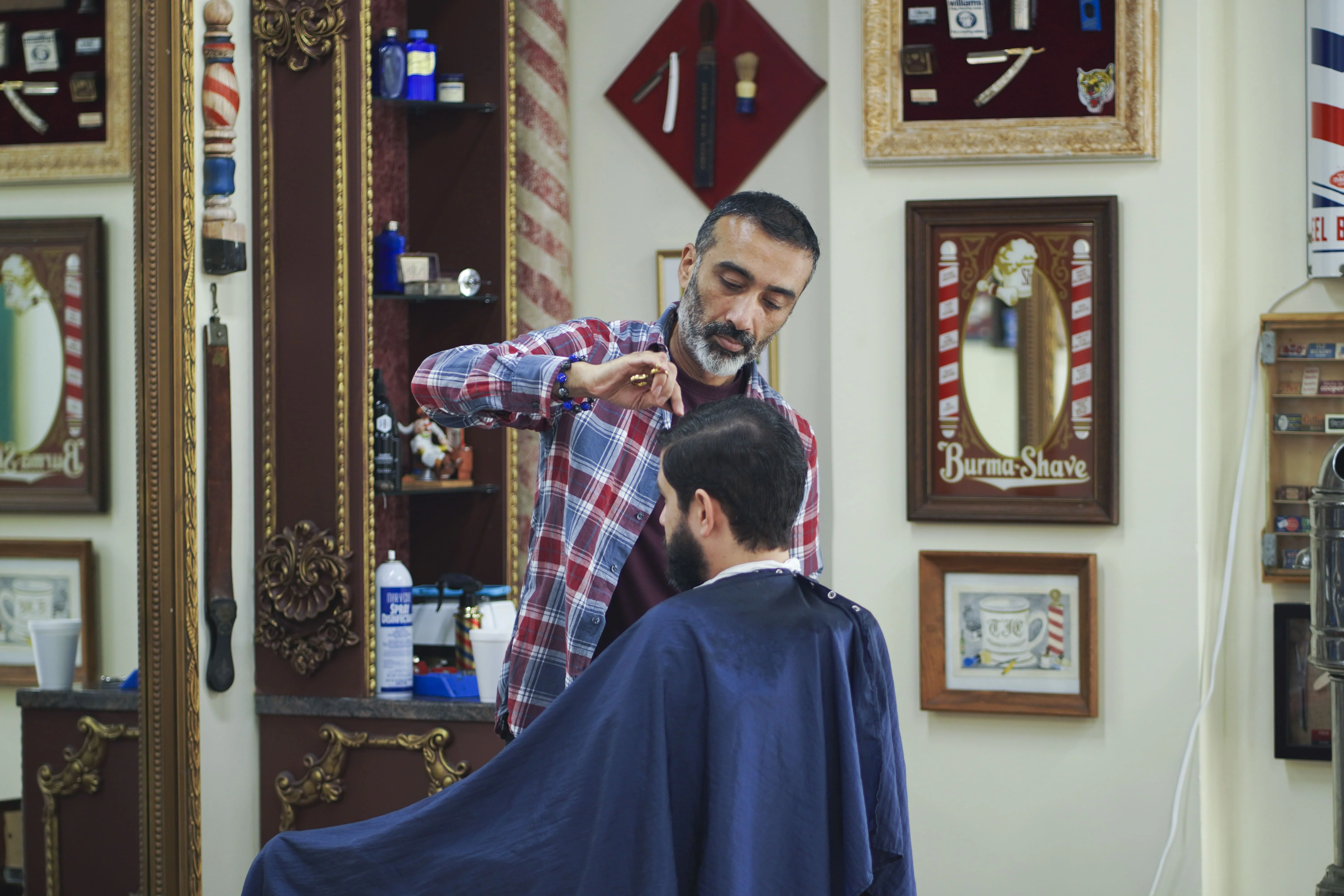 Arthur giving a scissor haircut to a client