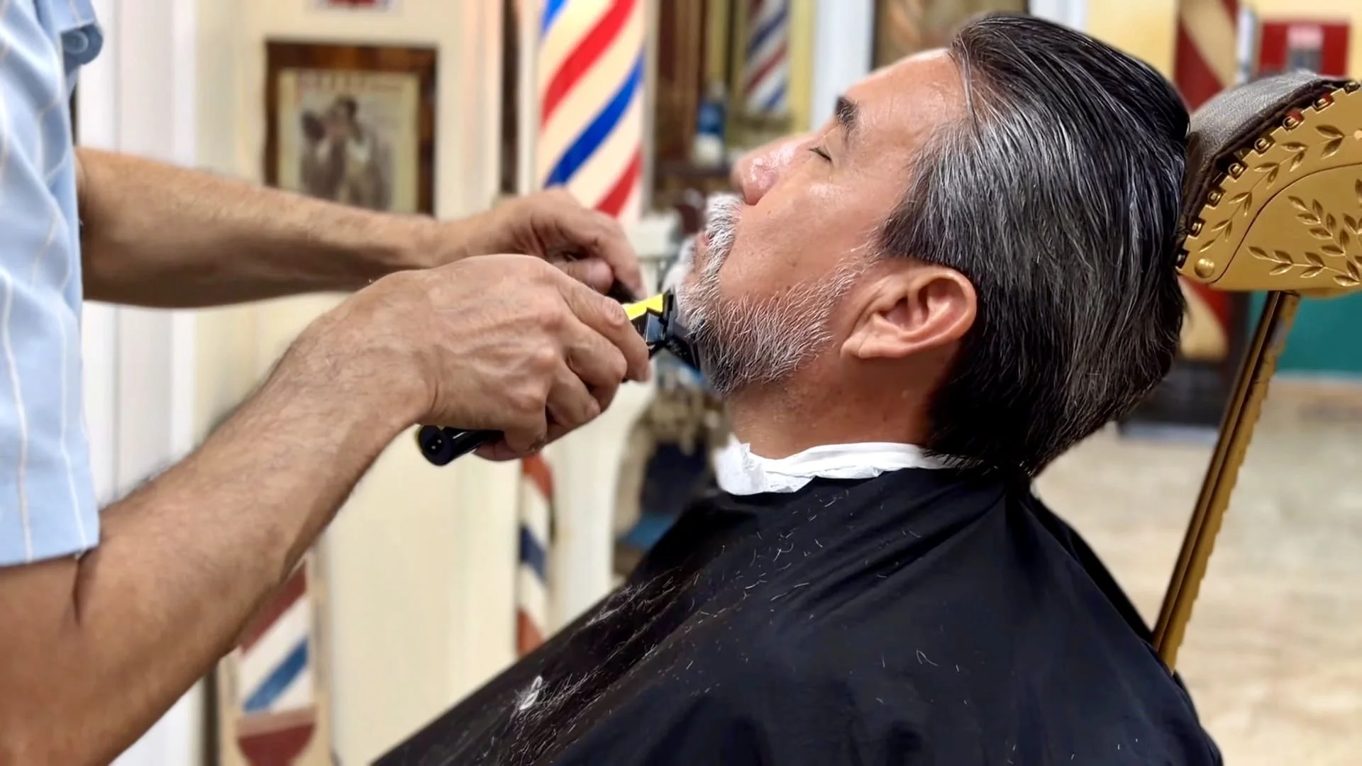 Client receiving a beard trim from a professional barber