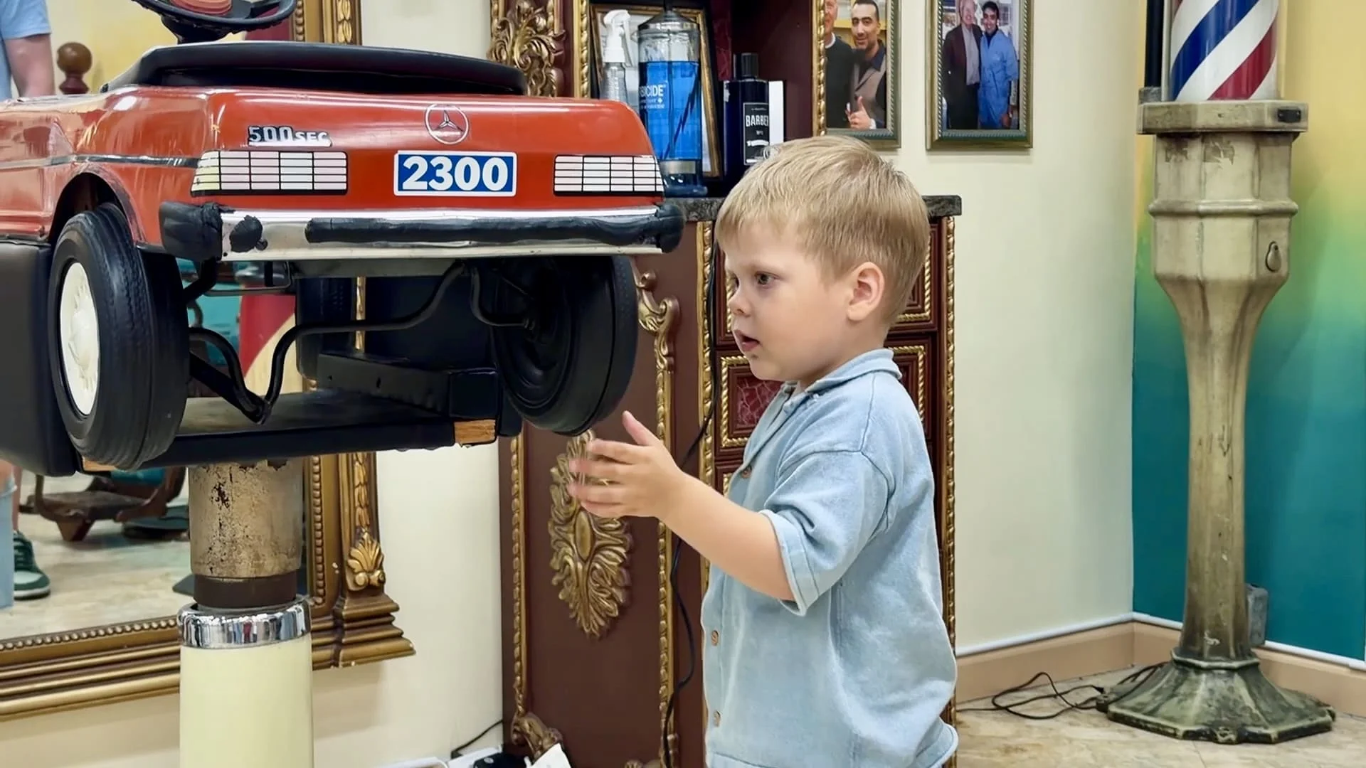 Child having fun with the car-shaped chair at our Sunny Isles Beach barbershop