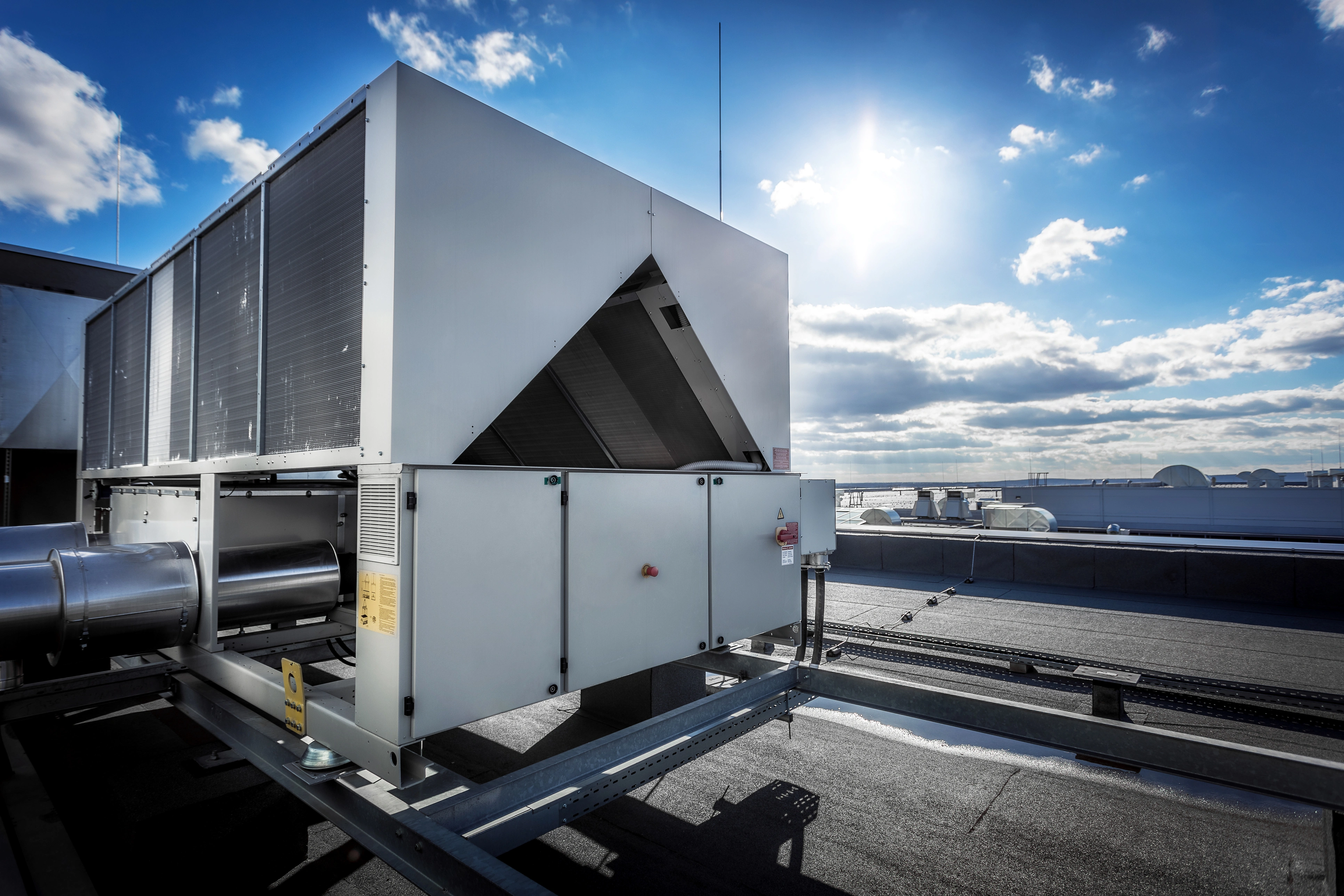 Rooftop industrial HVAC unit under a bright blue sky.
