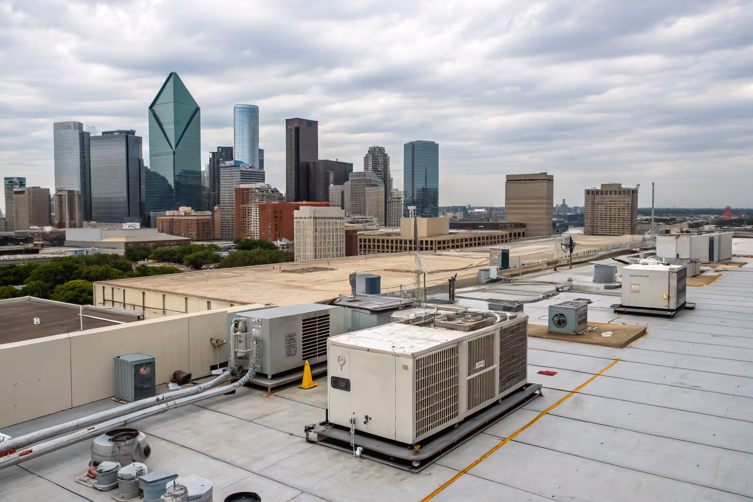 An HVAC array on top of a commercial building, with a city skyline in the background.