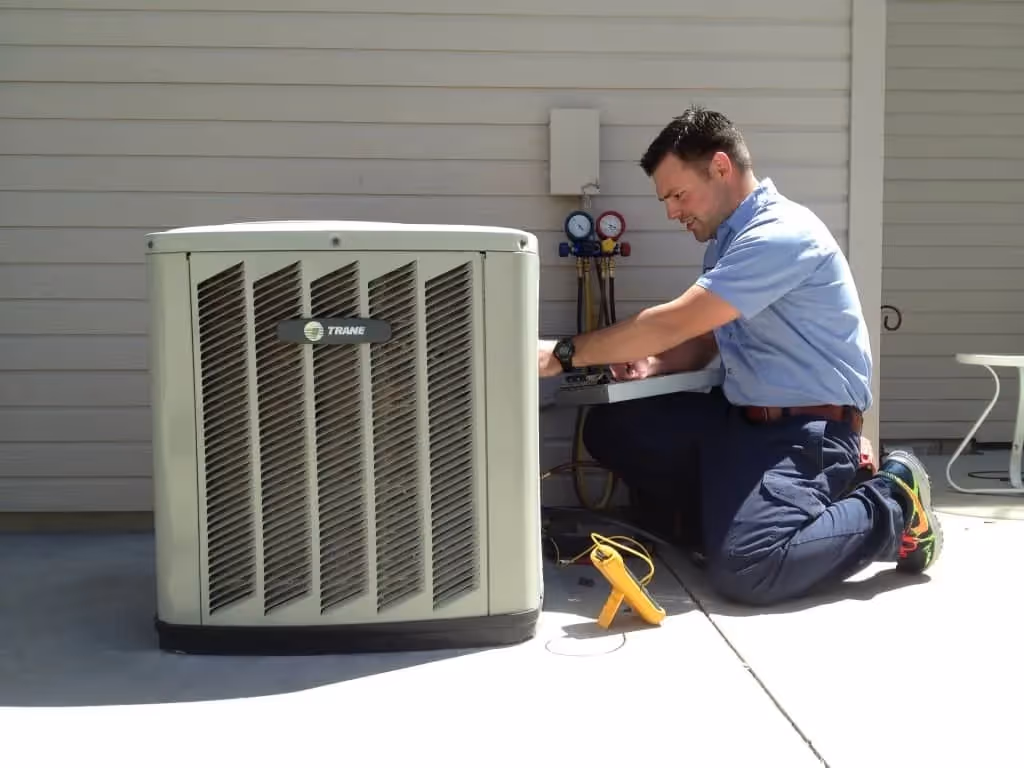 Technician servicing Trane outdoor AC unit.