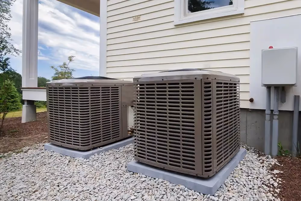 Two outdoor residential AC condenser units.