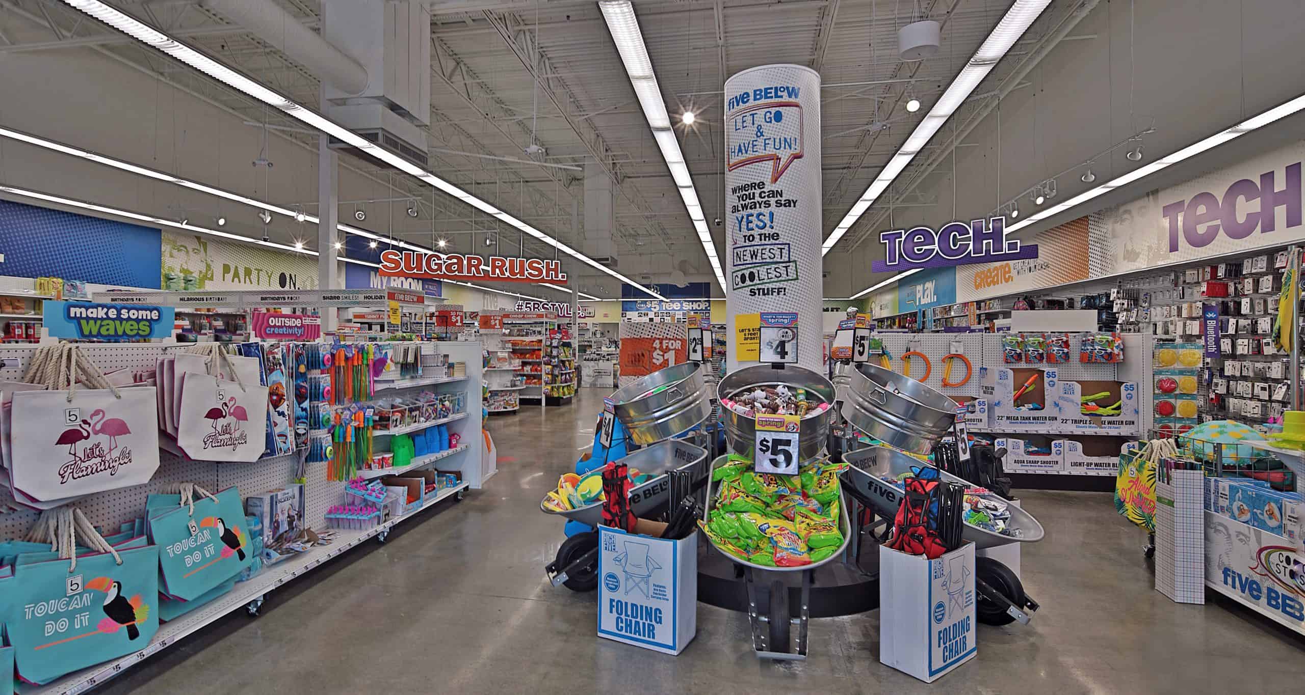 Merchandise aisles and central display bins inside Five Below in Evans, GA.
