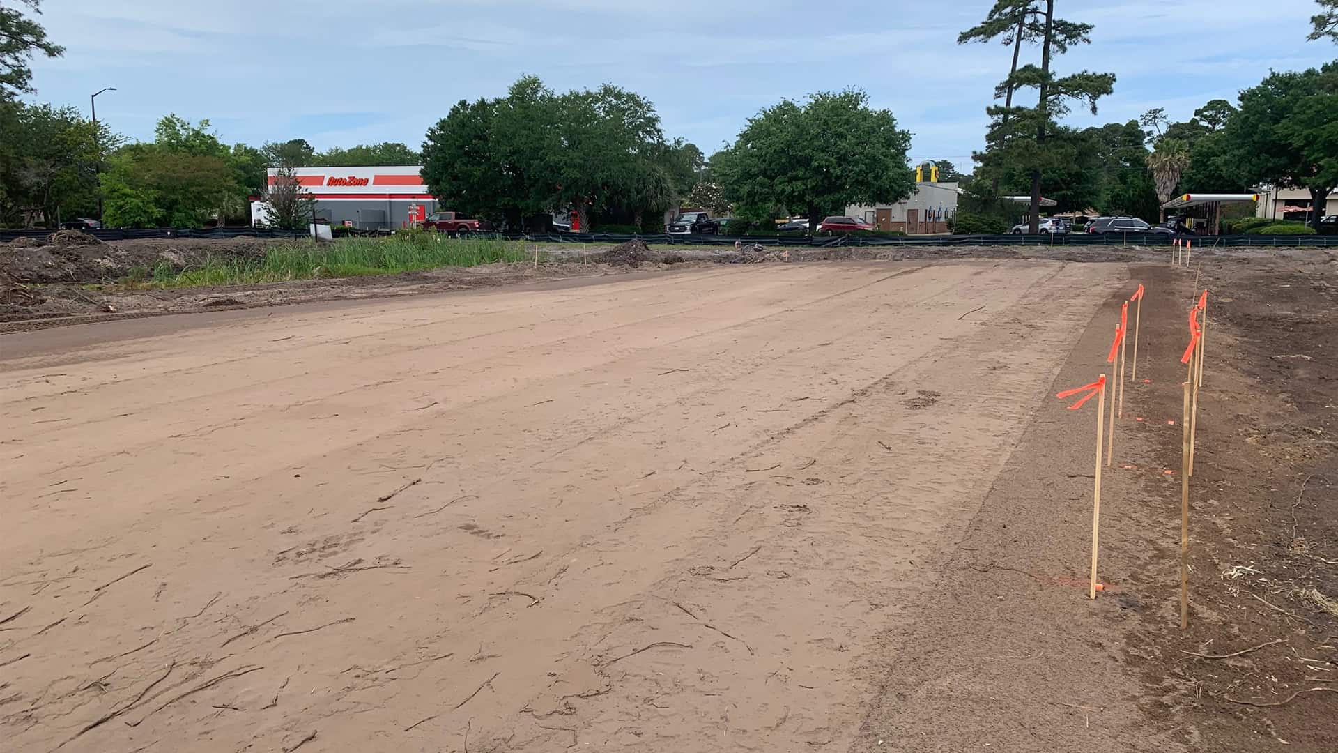 Leveled earth and flagged stakes at the Mavis Tire site in Savannah, GA.