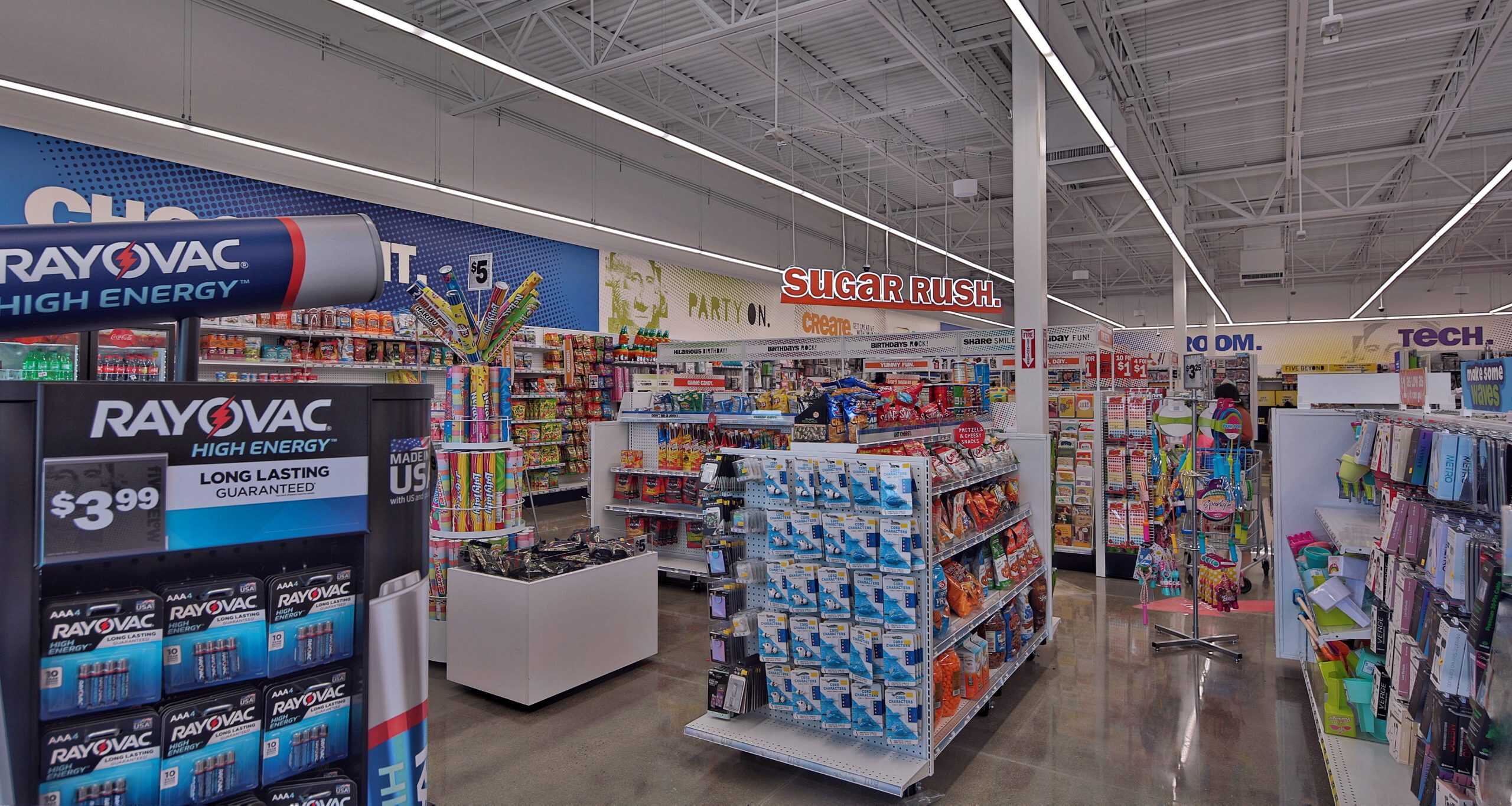 Stocked aisles beneath overhead section signs at Five Below in Holly Springs, NC.