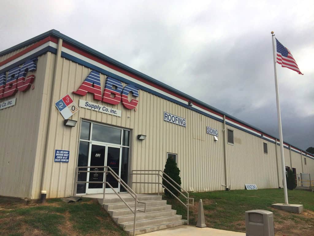 ABC Supply entrance, exterior signs, and flagpole in Fayetteville, NC.