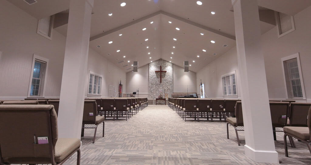 Central aisle and rows of chairs facing the sanctuary cross at Surfside Presbyterian in Surfside Beach.
