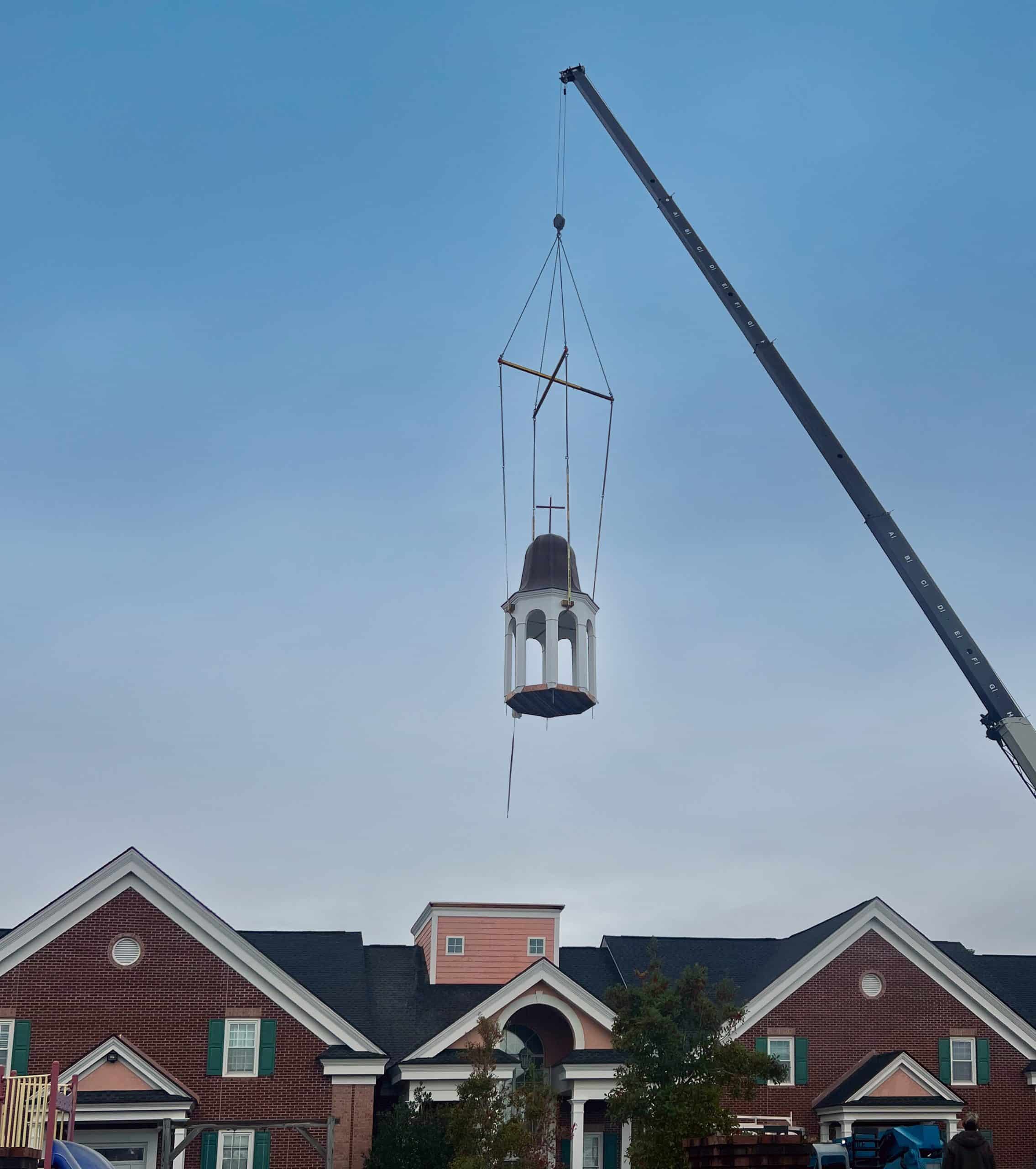 Crane lifting a steeple above the roof of Surfside Presbyterian in Surfside Beach.