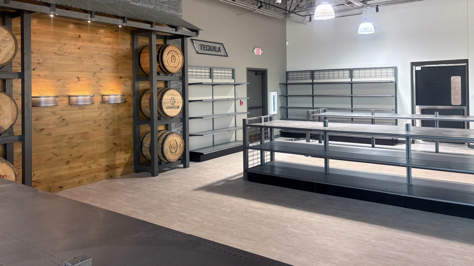 Wood accent wall, display barrels and retail shelving inside the ABC store in Greensboro, NC.