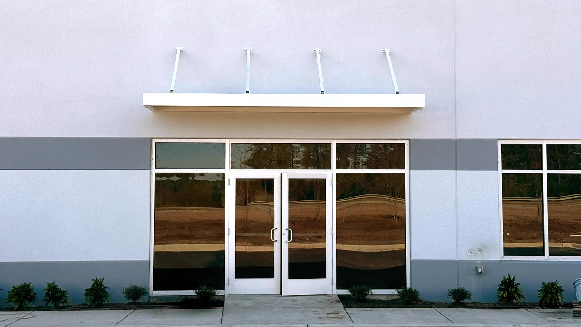 Glass entrance doors and metal canopy at ABC Supply on Water Tower Road in Longs, SC.