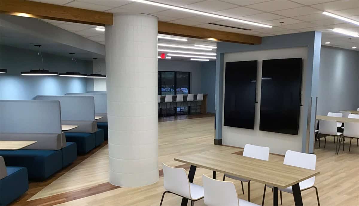 Booths, a column and long communal tables in the renovated hospital cafeteria.