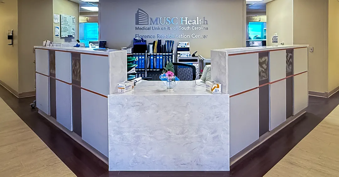 Reception counter beneath the Florence Rehabilitation Center sign at MUSC Health.