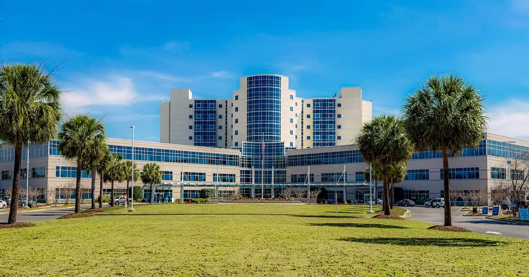 MUSC Florence Medical Center's central glass tower, front lawn and palm-lined approach.