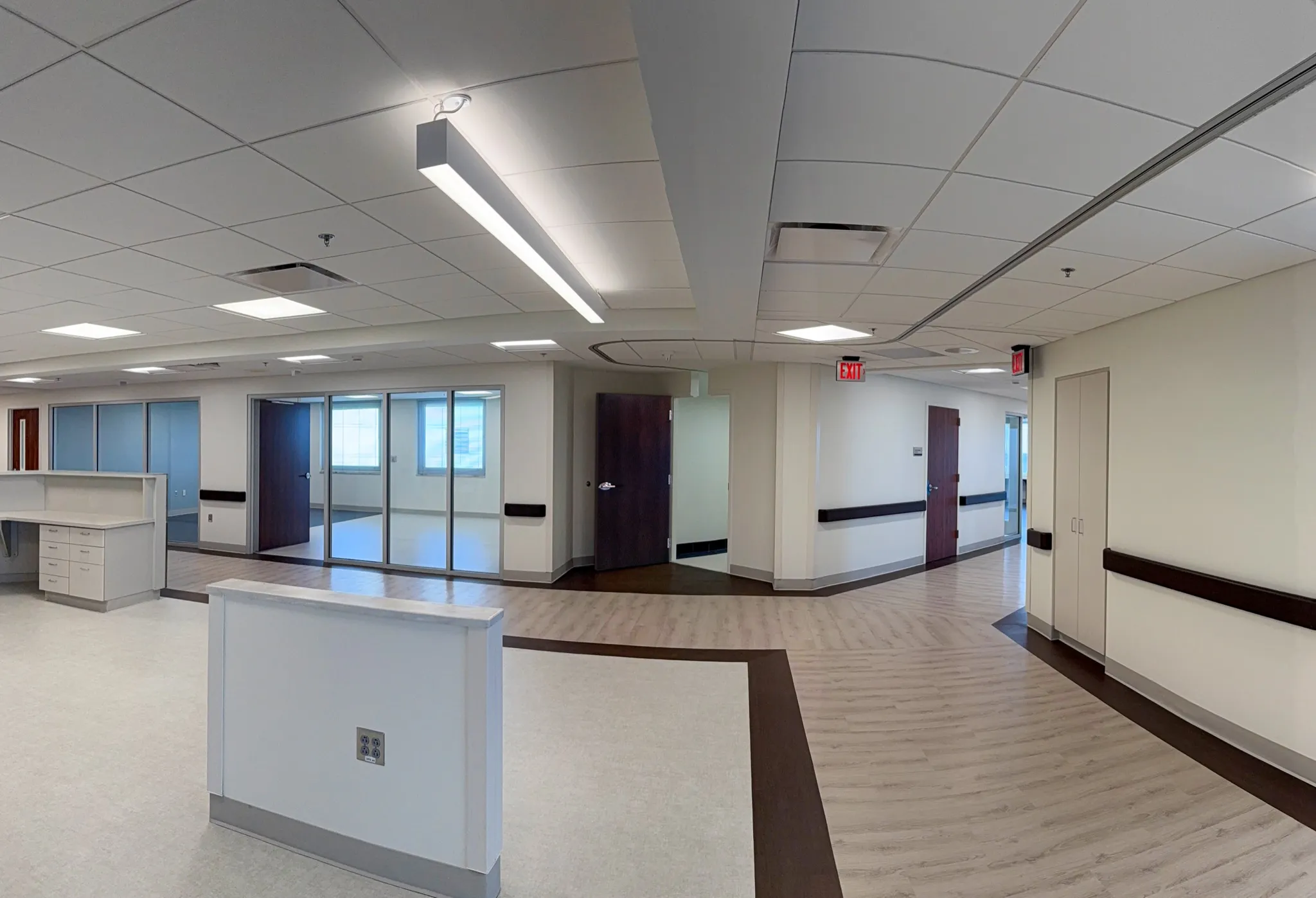 Ceiling lights above an open counter area and curved corridor at MUSC in Florence.