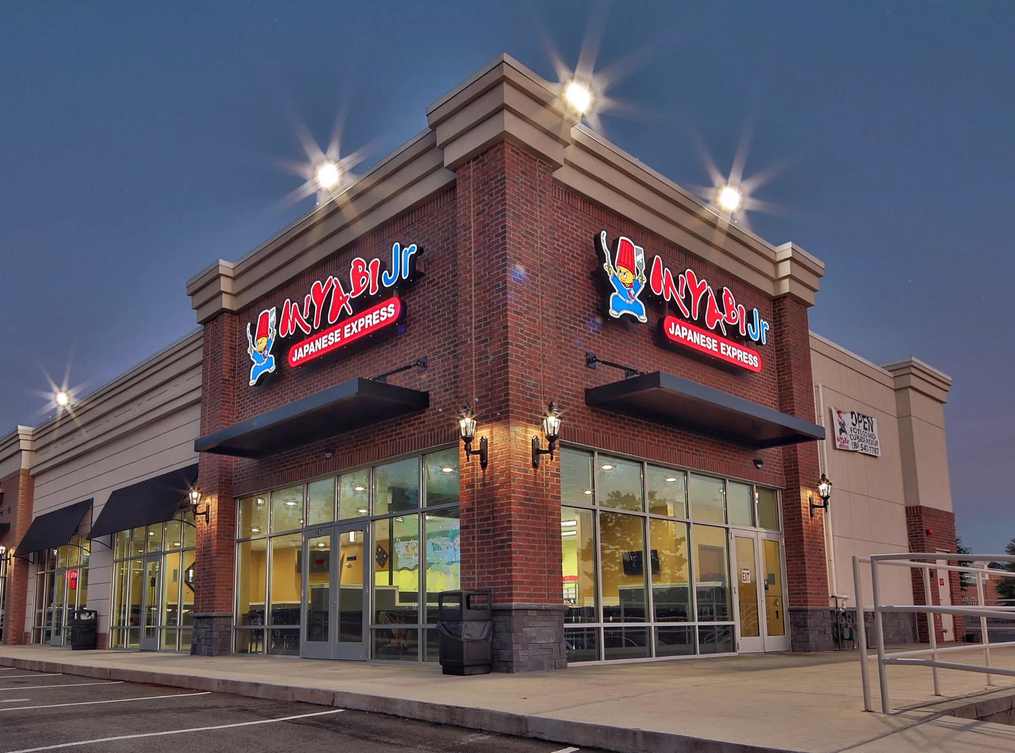 Illuminated Miyabi Jr. corner storefront in Tega Cay at dusk.