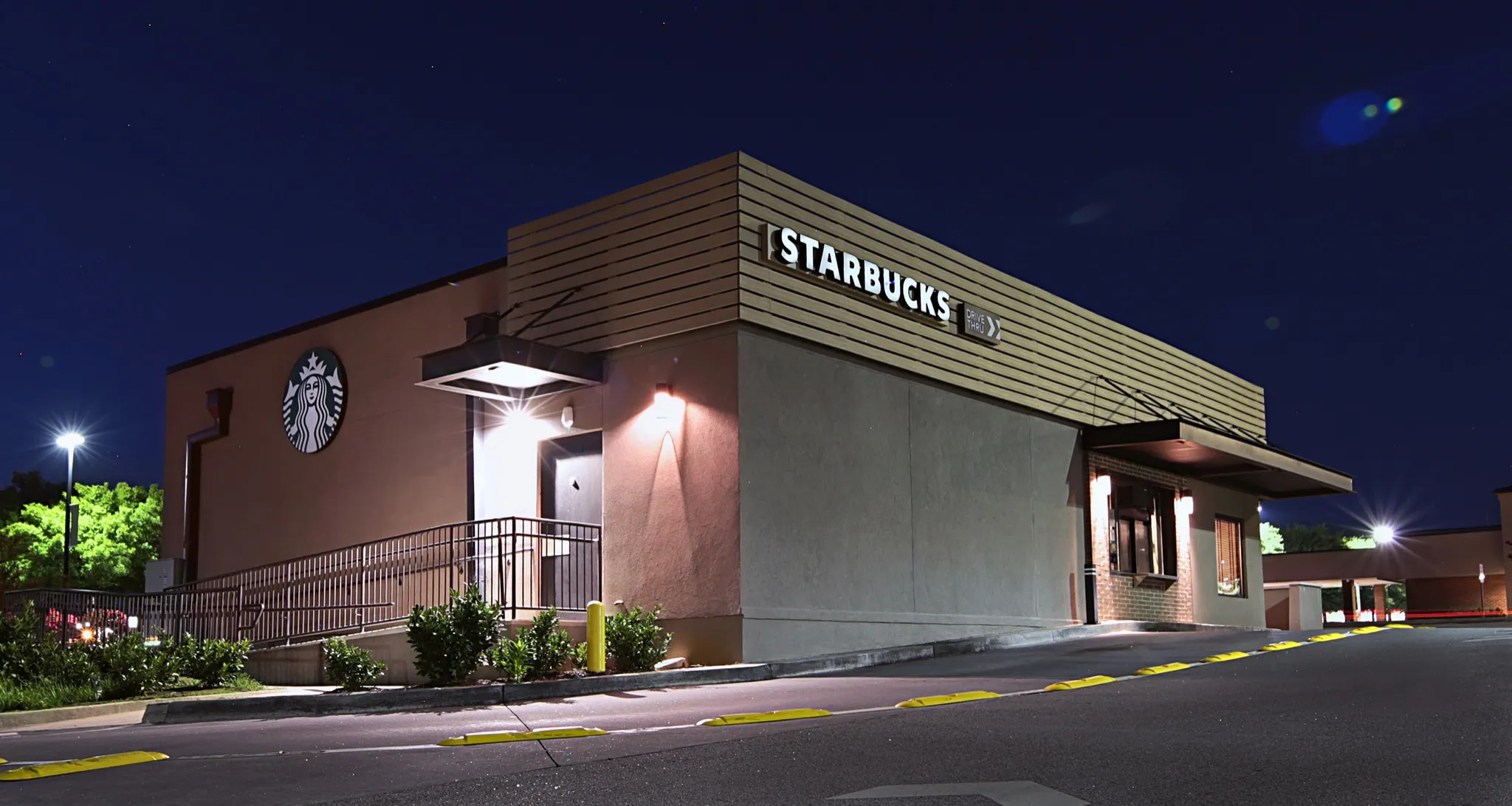 Starbucks Athens drive-through lane and illuminated exterior signs at night.