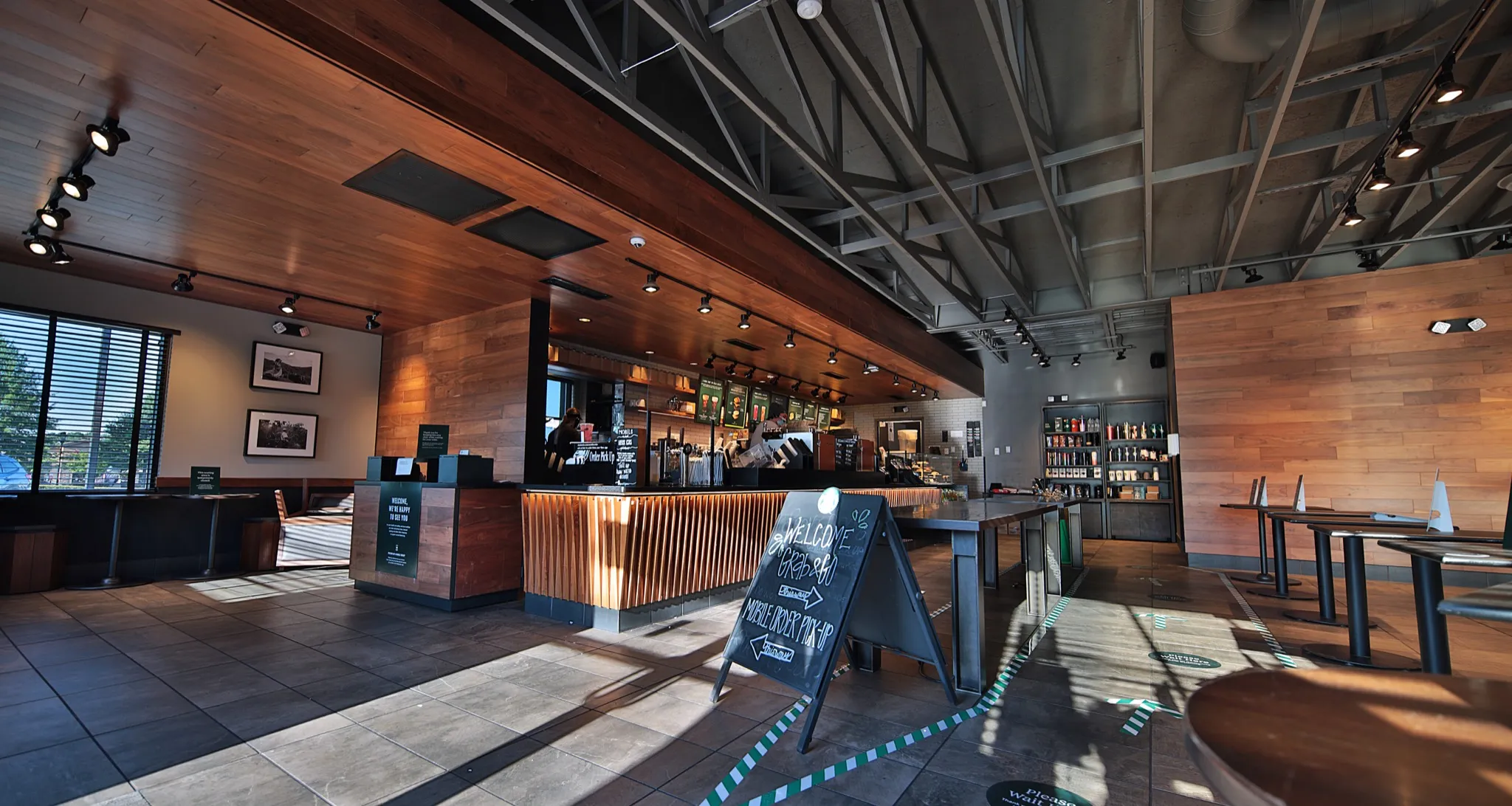 Starbucks Athens service counter beneath an exposed ceiling and wood-toned soffit.
