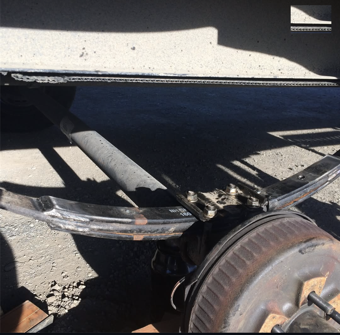 A broken trailer axle being repaired on the roadside