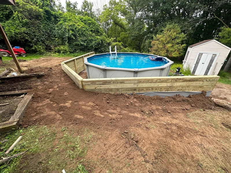 Wooden retaining wall built around above-ground pool.