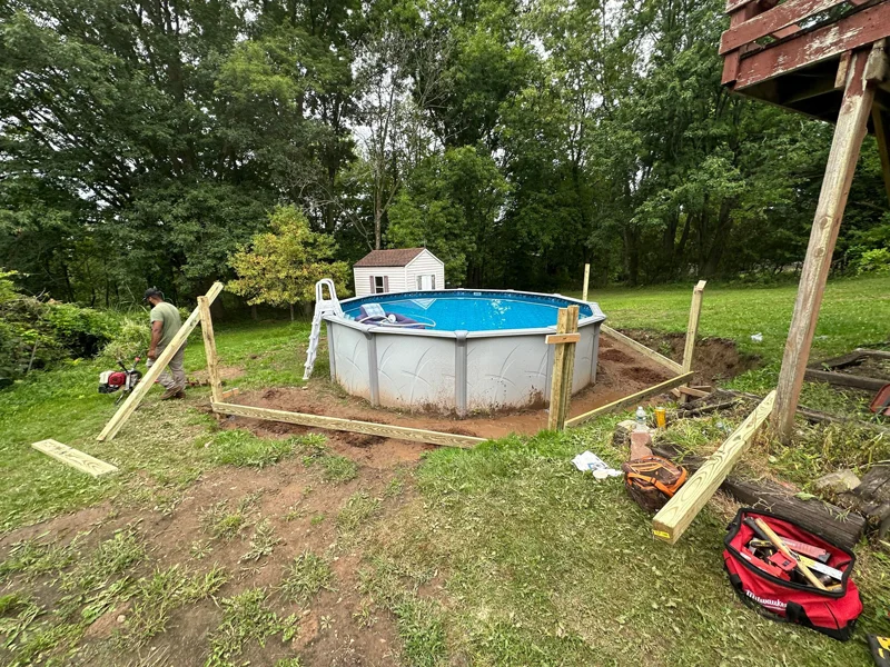 Wooden retaining wall built around above-ground pool.