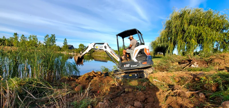 Clearing of riverside terrain with an excavator.