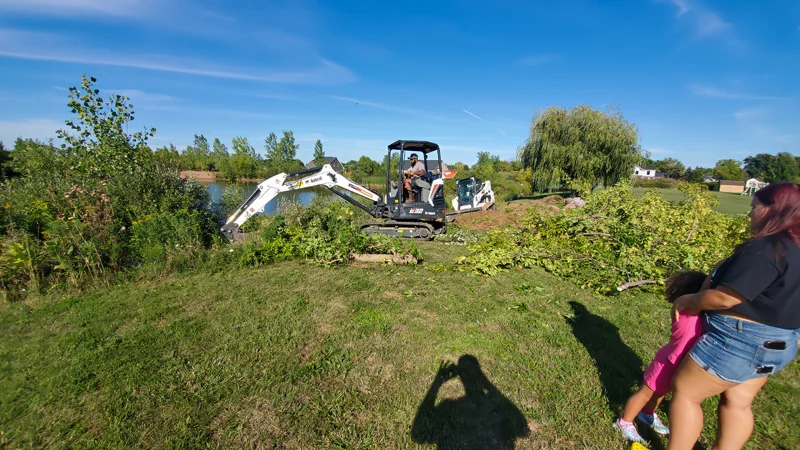 Clearing of riverside terrain with an excavator.
