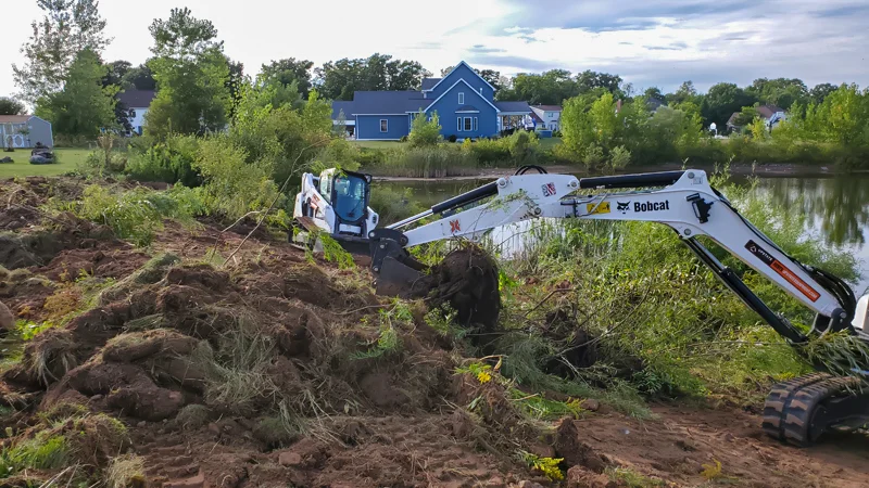 Clearing of riverside terrain with an excavator.