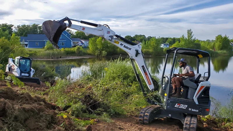 Clearing of riverside terrain with an excavator.