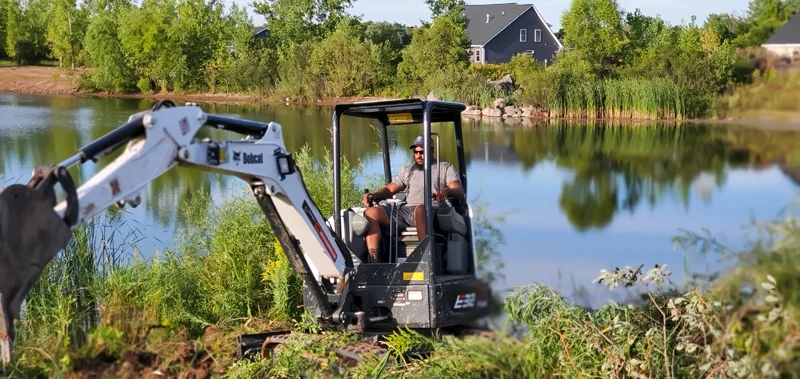 Clearing of riverside terrain with an excavator.