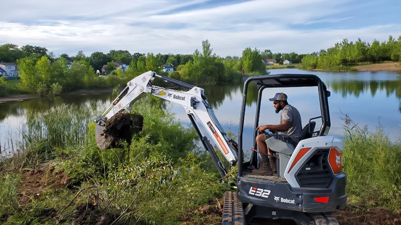 Clearing of riverside terrain with an excavator.