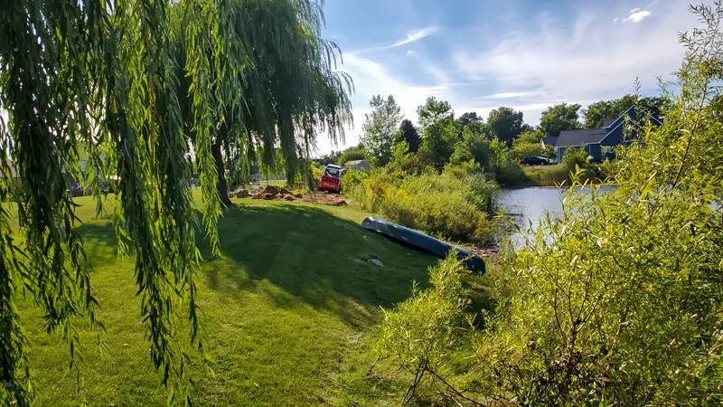 Clearing of riverside terrain with an excavator.