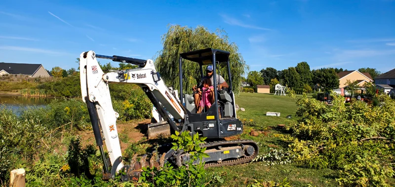 Clearing of riverside terrain with an excavator.