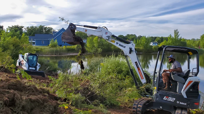 Clearing of riverside terrain with an excavator.