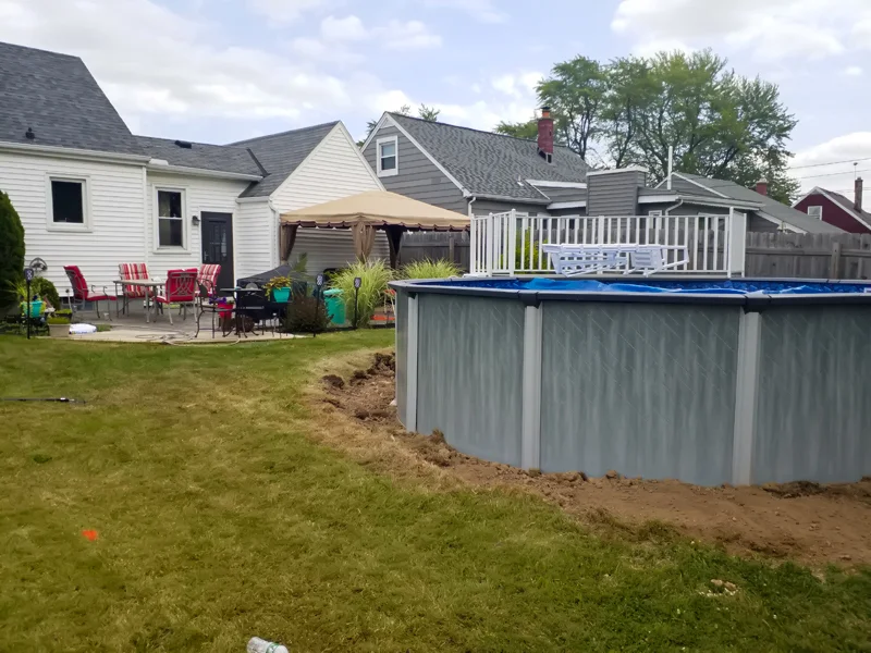 Poolside landscaping with gravel, pebbles, and prepared soil.