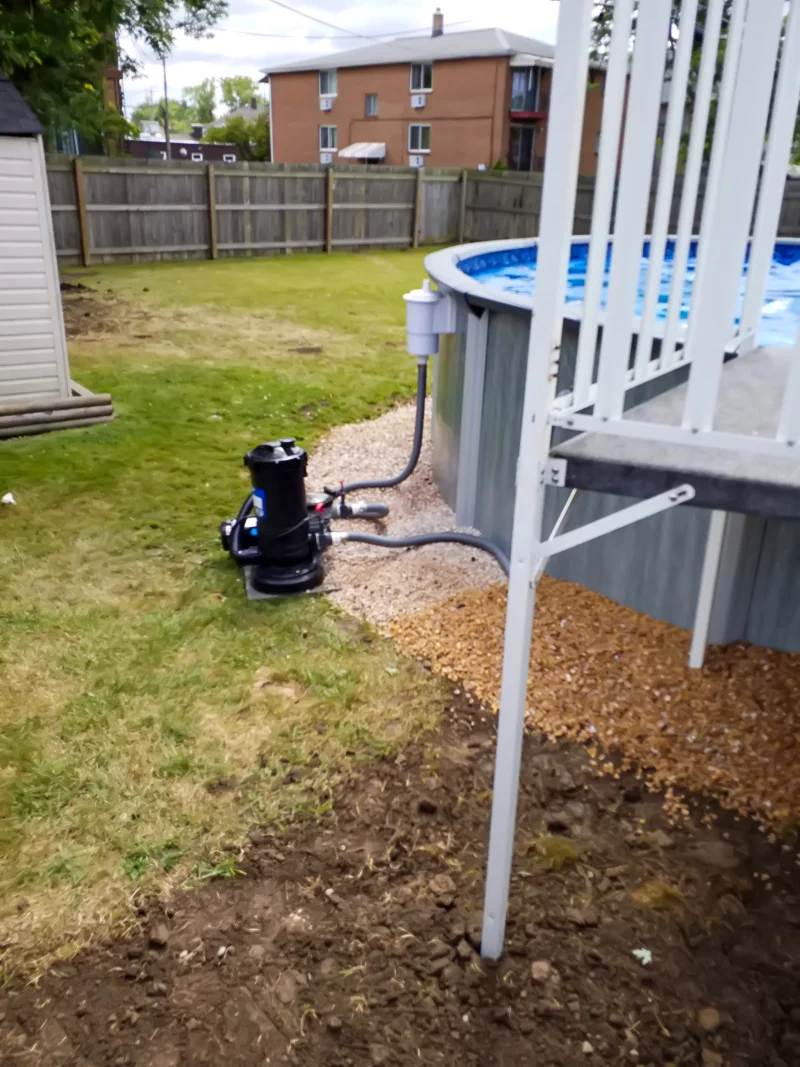 Poolside landscaping with gravel, pebbles, and prepared soil.