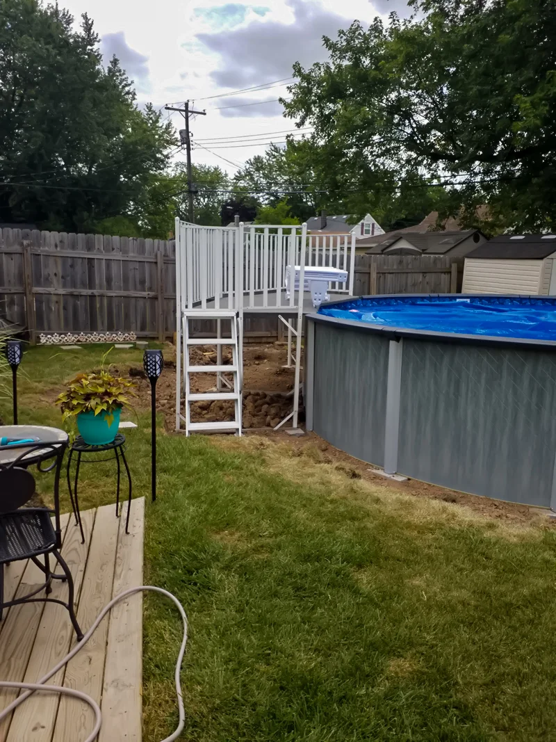Poolside landscaping with gravel, pebbles, and prepared soil.