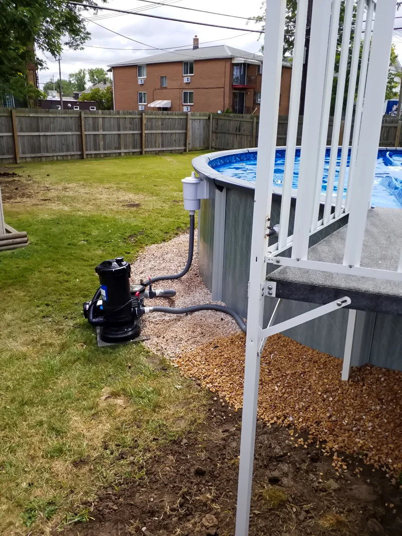 Poolside landscaping with gravel, pebbles, and prepared soil.