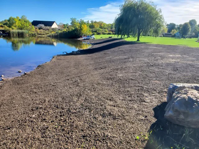 Clearing of riverside terrain with an excavator.