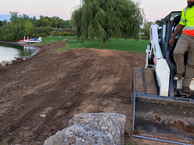 Clearing of riverside terrain with an excavator.